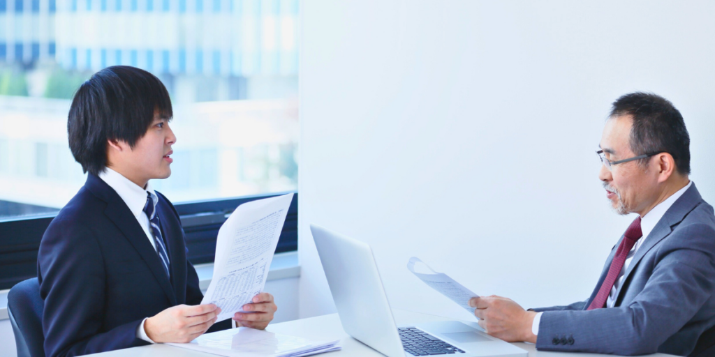 مقابلة عمل رسمية بين مدير التوظيف ومرشح وظيفة أثناء مراجعة السيرة الذاتية