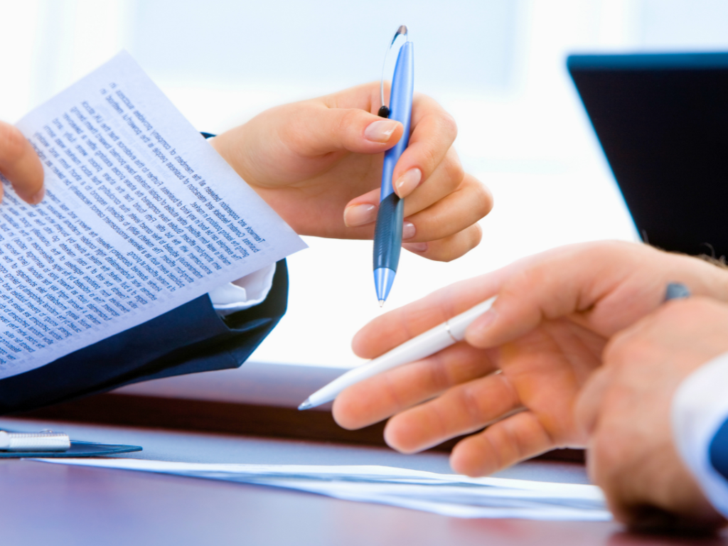 رجل يوقع على فسخ عقد عمل ويقرا شروطه